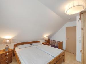 ein Schlafzimmer mit einem Bett und zwei Nachttischen in der Unterkunft Haus am Meer 63 in Kaltenhof