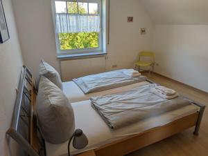 twee bedden in een kamer met een raam bij Haus Christof - Hooksiel in Wangerland