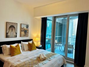 een slaapkamer met een groot bed en een balkon bij Exquisite Spacious Deluxe one bedroom Apartment, Stunning Marina Views, Full Kitchen High-Speed Internet, Dubai Marina Gem, By "La Buena Vida Holiday Homes" in Dubai