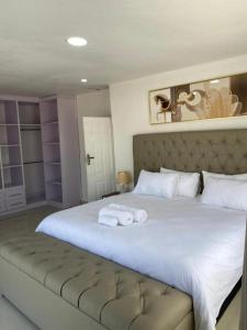 a bedroom with a large white bed with towels on it at Swiss Luxury Apartments in Ndola