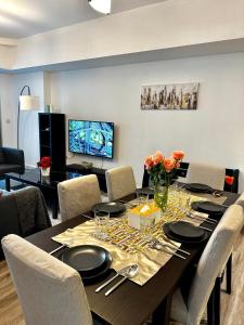 een eetkamer met een tafel met stoelen en een televisie bij Exquisite Spacious Deluxe one bedroom Apartment, Stunning Marina Views, Full Kitchen High-Speed Internet, Dubai Marina Gem, By "La Buena Vida Holiday Homes" in Dubai