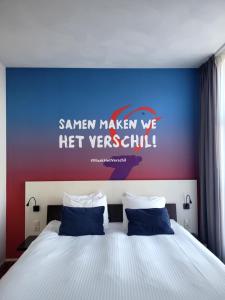 a bedroom with a bed with a blue and red wall at Hotel de Wereld in Wageningen