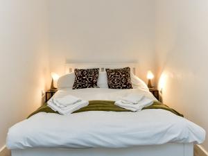 een slaapkamer met een wit bed en 2 handdoeken bij Pass the Keys Sleeps 5 close to Bay City in Cardiff
