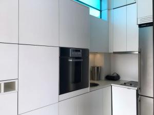 a kitchen with white cabinets and a black oven at luxury ph private pool+roof garden in Athens
