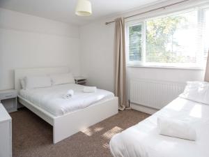 a bedroom with two beds and a window at Pass the Keys 10 mins to City Centre Sleeps 6 in Manchester