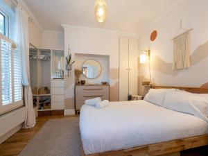 a bedroom with a white bed and a mirror at Pass the Keys West Didsbury Apartment w Garden sleeps 4 in Manchester