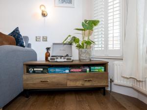 a living room with a wooden dresser with a plant at Pass the Keys West Didsbury Apartment w Garden sleeps 4 in Manchester