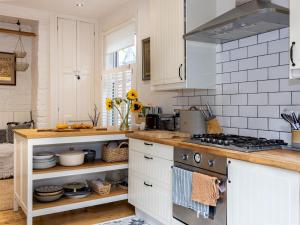 a kitchen with white cabinets and a stove at Pass the Keys West Didsbury Apartment w Garden sleeps 4 in Manchester