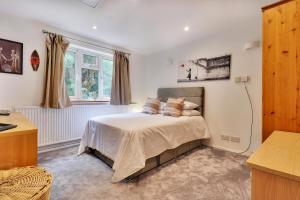 a bedroom with a bed and a window at Pass the Keys Large family home in picturesque village in Westerham