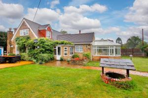 a house with a fire pit in the yard at Pass the Keys Large family home in picturesque village in Westerham