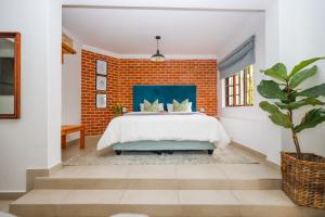 a bedroom with a brick wall and a bed at The Blue Door Guesthouse in East London