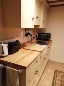a kitchen with a counter top and a microwave at 1 Bed cottage The Stable at Llanrhidian Gower with sofa bed for additional guests in Swansea