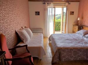 a bedroom with a bed and a chair and a window at Gîte LES GOUTTES in Courzieu