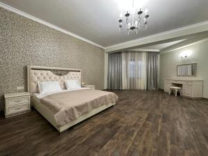 una camera da letto con un letto grande e un lampadario di Gandzak Hotel a Vanadzor