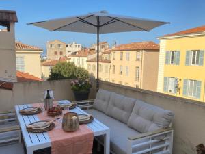 a white table with an umbrella on a balcony at Enjoy Antibes in Antibes