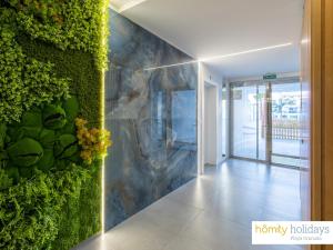 a hallway with a wall covered in green plants at Homity Exclusive Playa Granada Beach & Golf - Aguacate Beach in Motril