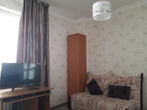 sala de estar con TV y sofá en Zhenis street en Astaná