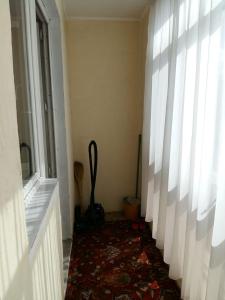 a hallway with a room with a window and a rug at Zhenis street in Astana