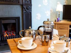 a table with two coffee pots and cups on it at Elder Grove in Ambleside