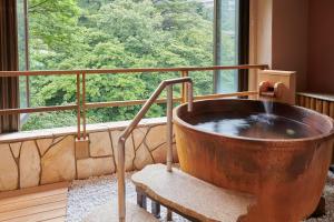 a large wooden tub in a room with a window at 日光ガーデンホテル in Nasushiobara