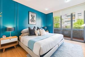 a bedroom with blue walls and a bed with pillows at Trendy La Roma Condo with Parking & Patio in Mexico City