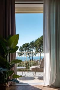 a room with a balcony with a view of the ocean at Bed & Breakfast LA HOME and Apartments in Moniga