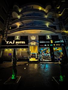 una tienda frente a un edificio por la noche en TAJ Hotel en Áqaba