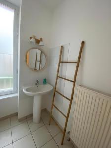 a bathroom with a sink and a mirror and a ladder at Appartement cosy à Vals in Vals-les-Bains