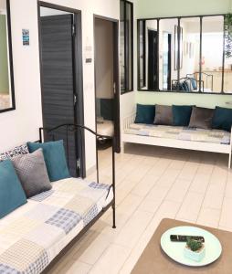 uma sala de estar com um sofá e uma mesa em Appartement en rez-de-villa avec jardin em Hyères