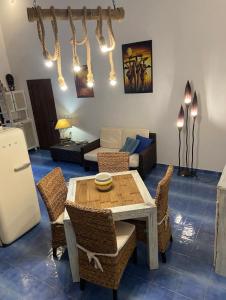 a living room with a table and chairs and a couch at Casa Ada - Incantevole loft in centro in Lampedusa +13 photos