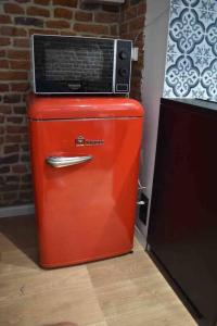 a red refrigerator with a microwave on top of it at Charmant Studio au Cœur de Béthune in Béthune