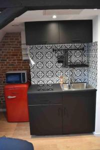 - une cuisine avec un évier et un mur en briques dans l'établissement Charmant Studio au Cœur de Béthune, à Béthune