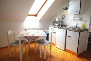 a kitchen with a table with chairs and a sink at Ferienpark am Darß - Apartmenthaus 3 in Fuhlendorf