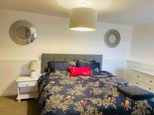 um quarto com uma cama com uma almofada vermelha em The Mill Stylish Rural Apartment with Beautiful Views em Welsh Newton Common