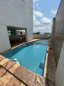 a swimming pool in the side of a building at Flat Praia de PontaNegra - Natal RN in Natal
