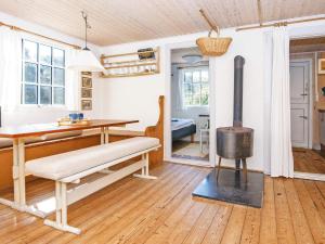 uma sala de estar com um fogão a lenha e uma mesa em 4 person holiday home in Ulfborg em Fjand Gårde