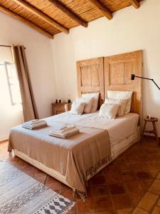 a bedroom with a large bed with a wooden headboard at Villa a Vida 