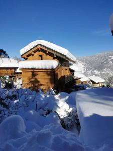 a cabin covered in snow with a pile of snow at Meribel le chalet d'eugénie in Les Allues