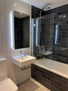 a bathroom with a sink and a shower and a toilet at Stylish Apartment Docklands in London
