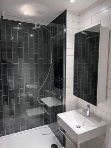 a black and white bathroom with a sink and a shower at Stylish Apartment Docklands in London