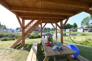 una mesa de picnic de madera bajo un pabellón en un campo en Domaine de la Roselière, en Noyelles-sur-Mer