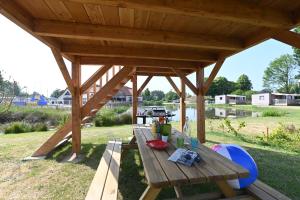 una mesa de picnic de madera bajo un pabellón en un campo en Domaine de la Roselière, en Noyelles-sur-Mer