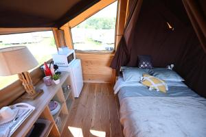 a small room with a bed in a tent at Domaine de la Roselière in Noyelles-sur-Mer