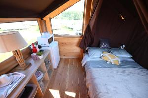 mały pokój z łóżkiem w namiocie w obiekcie Domaine de la Roselière w mieście Noyelles-sur-Mer