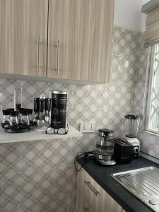 een keuken met een aanrecht en een koffiezetapparaat bij Newly built house in Accra in Danfa