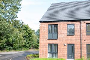 een rood bakstenen huis met een zwart dak bij Pass the Keys Beautiful Glasgow South Home in Glasgow