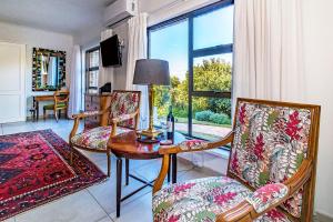 a living room with a table and chairs and a window at 5 Rembrandt Guesthouse in Somerset West