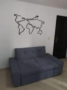 ein blaues Sofa in einem Zimmer mit einer Karte an der Wand in der Unterkunft MALAGA in Sabaneta