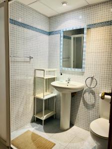 a bathroom with a sink and a toilet and a mirror at Guest house Teatinos in Málaga