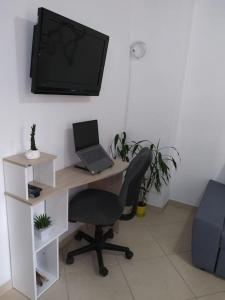 ein Büro mit einem Schreibtisch, einem Laptop und einem TV in der Unterkunft MALAGA in Sabaneta